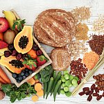 Healthy high fibre diet food concept with legumes, fruit, vegetables, wholegrain bread, cereals, grains, nuts and seeds. Super foods high in antioxidants, anthocyanins, omega 3 and vitamins.