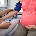Checking blood pressure of pregnant woman