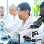 Scientist working in lab. Doctors making medical research. Biotechnology, chemistry, science, experiments and healthcare concept. Day light and window background.