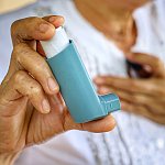 Image of a person holding an inhaler