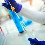 Image of a scientist holding a swab and test tube.