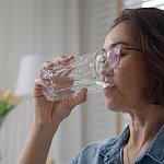 Close-up asia elder people or latin lady hold clean spring cold alkaline water in hand drink sip joy relax help aging face skin benefit for female, routine life balance weight loss by nature taste.