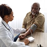 Hypertension In Older Age. Young Female Medical Worker Measuring Arterial Blood Pressure Of Senior Black Man Using Cuff, Patient Having Problems With Tension
