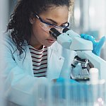 Medical Science Laboratory: Portrait of Beautiful Black Scientist Looking Under Microscope Does Analysis of Test Sample. Ambitious Young Biotechnology Specialist, working with Advanced Equipment