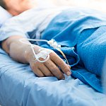 Focus on the hand of a patient in hospital ward