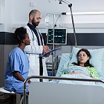 Photo of recovering young woman on hospital bed