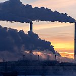 Emission to atmosphere from industrial factory chimney. Smokestack pipes shooted with drone. Global warming concept and air pollution. Aerial view.