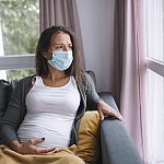 Image of a pregnant person looking out a window