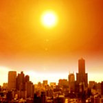 Image of a bright sun over a city skyline