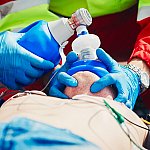 A rescue team using a bag-mask device to resuscitate a man who has experienced cardiac arrest.