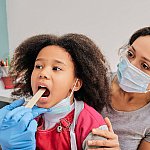 Image of a young girl getting a tonsil exam