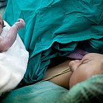 Newborn baby next to mother in hospital birth setting