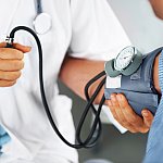  Image of a medical professional taking a person’s blood pressure