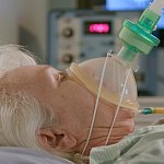 Image of an older woman on ventilator life support