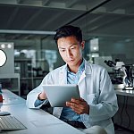 Tablet, planning and scientist with digital innovation, data and reading in laboratory. Asian man, doctor and information technology for futuristic medical research with pharma healthcare study 