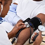 Image of a health care worker administering a blood pressure cuff