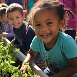 AI-generated young children tending to plants in a community garden.