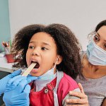 image of a young girl receiving a tonsil exam.