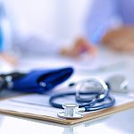 Image of a stethoscope on top of a pad of paper
