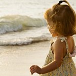 Picture of a little girl standing by the ocean