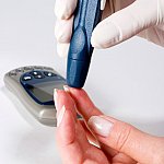 Photo of a person administering a blood glucose test
