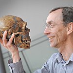 Photo of Dr. Svante Pääbo holding a Neanderthal skull