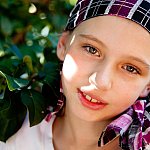 Photo of a young girl wearing a headscarf, smiling