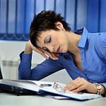 Photo of a woman nodding off at her desk