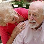 Photo of an older woman caring for her husband