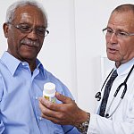 Doctor showing patient prescription bottle.