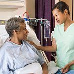 Nurse helping hospital patient.