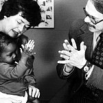 Caregivers clapping with baby.