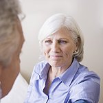 Doctor taking woman’s blood pressure.