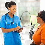 Nurse and senior patient, both African American