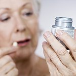 Senior woman holding a bottle of pills