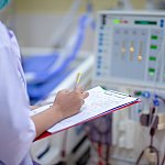 Nurse checking a dialysis machine