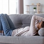 Tired young woman lying on a couch