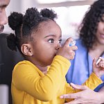 Girl using an asthma inhaler