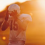 Football player holding helmet