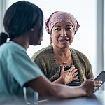 Woman looking at tablet with a female physician