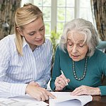 Woman helping senior with paperwork