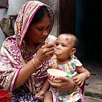 Mother feeding young child