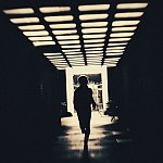 Person in shadow running through creepy underpass