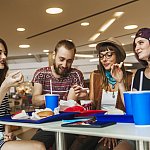 Hipster friends in mall eating fast food