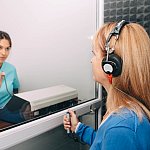 Audiologist doing a hearing exam on an older woman
