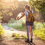 Woman applying insect repellent as mosquitoes fly around her