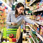 Woman selecting groceries from a shelf.