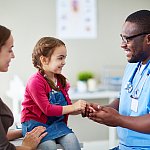 Small child and doctor talking in clinic