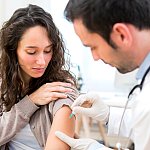 Young woman being vaccinated.