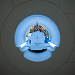 View through an fMRI scanner as three researchers peer inside.